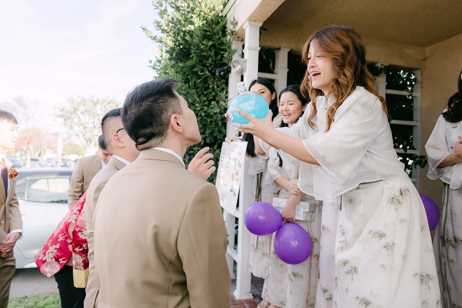 A groomsman takes on a balloon challenge from the bridesmaids