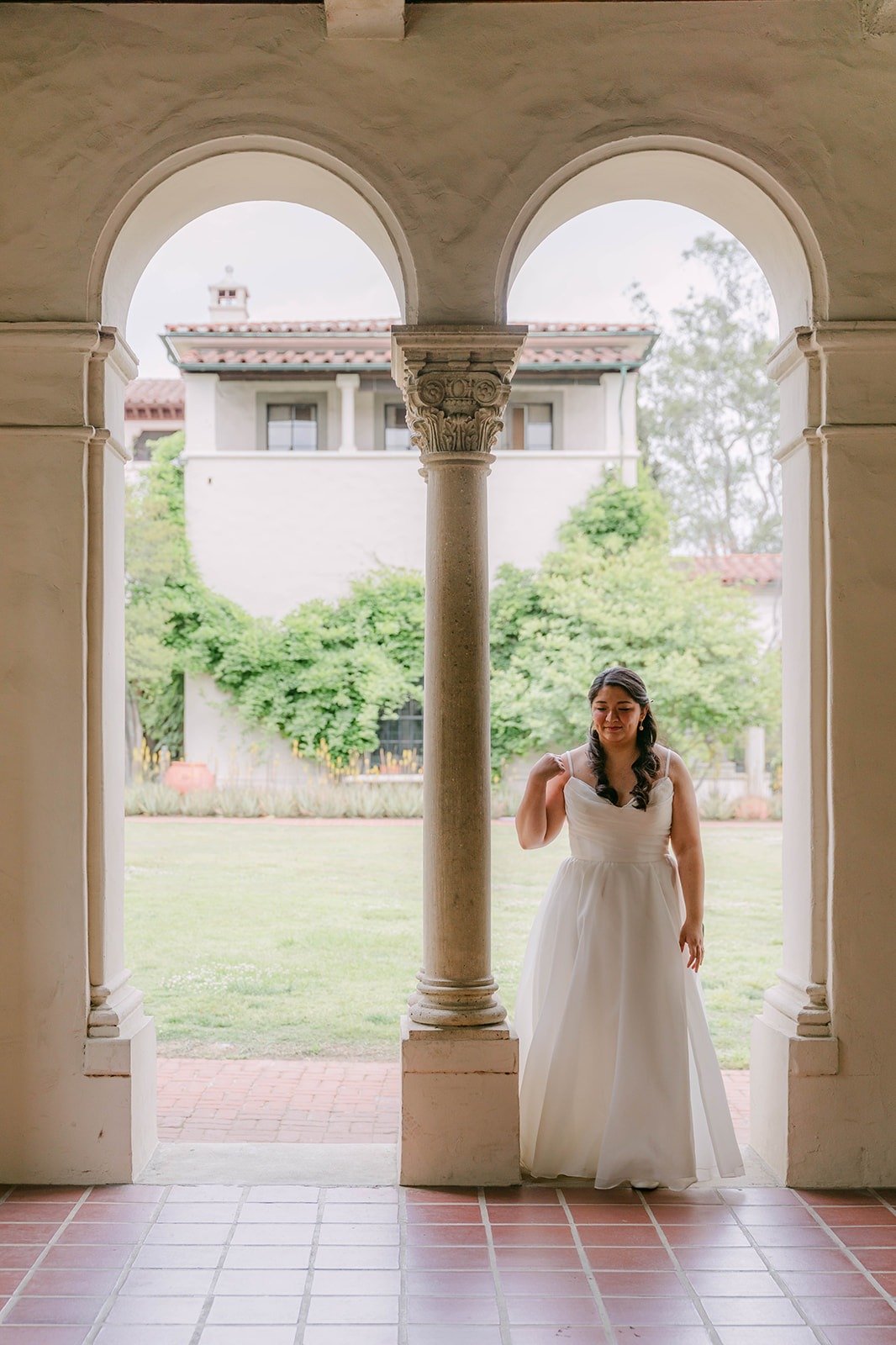 Saira framed by an arched loggia at The Athenaeum at Caltech