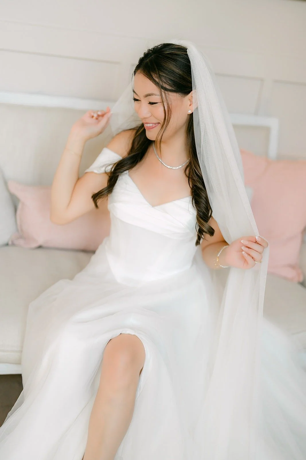 Jadee laughing under her veil in the bridal suite