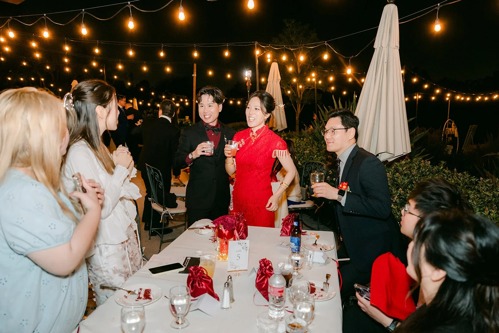 Guests toasting under the string lights.