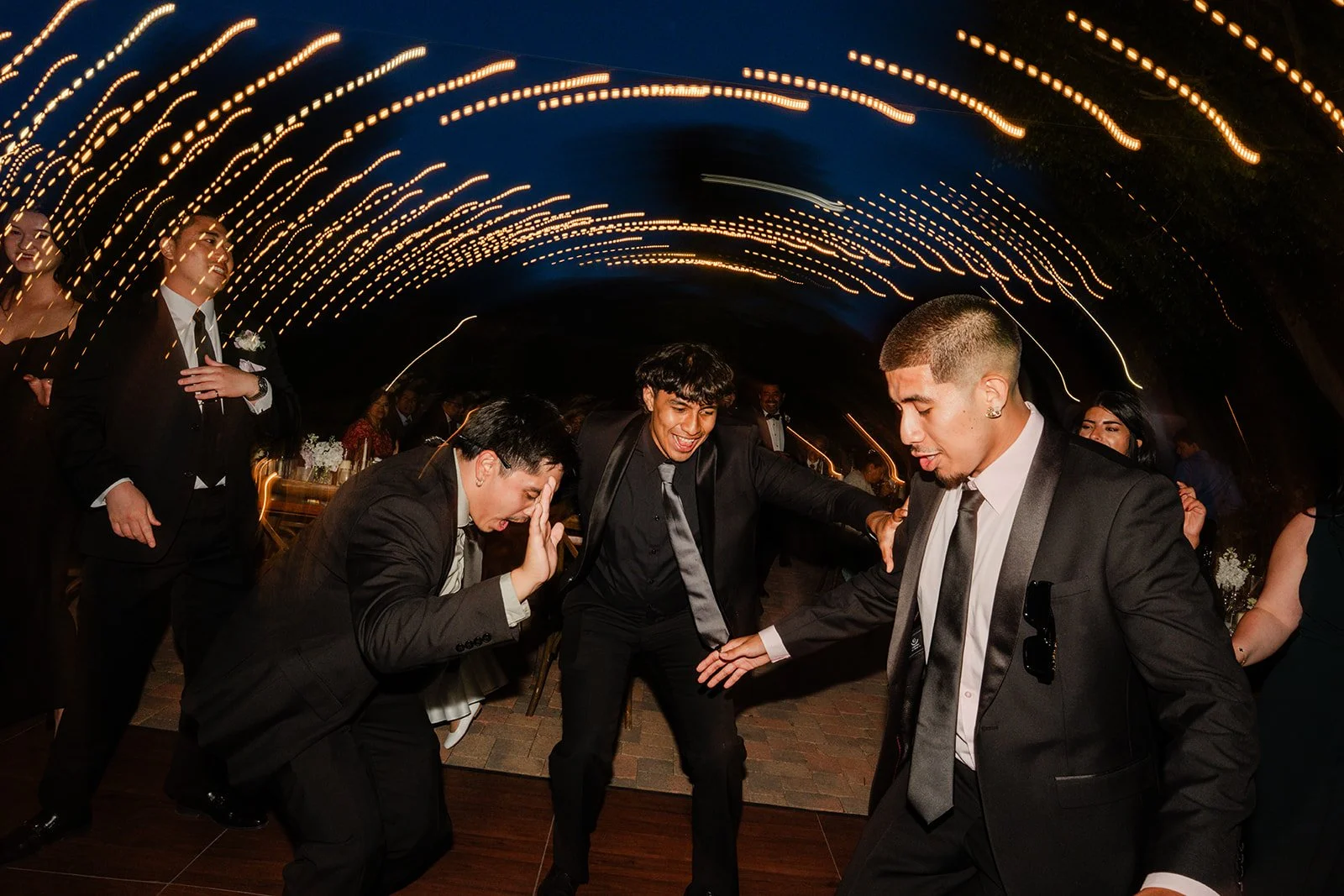 Guests dancing under light trails at the reception