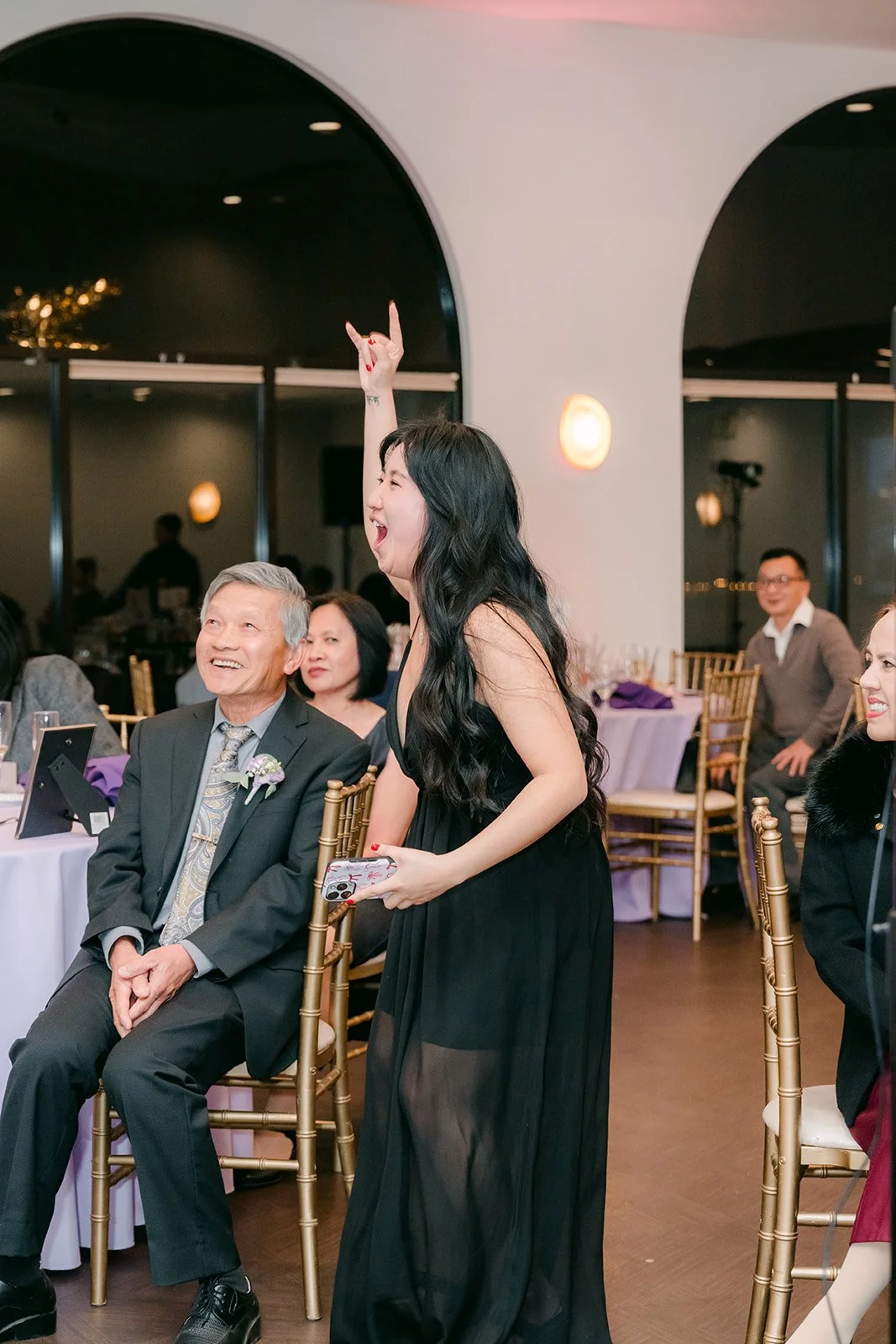 A guest celebrating after catching the bouquet, photographed by One and Only Production.