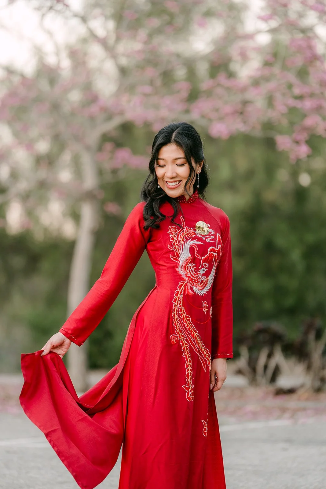 Kim smiling as she holds out the panel of her ao dai.