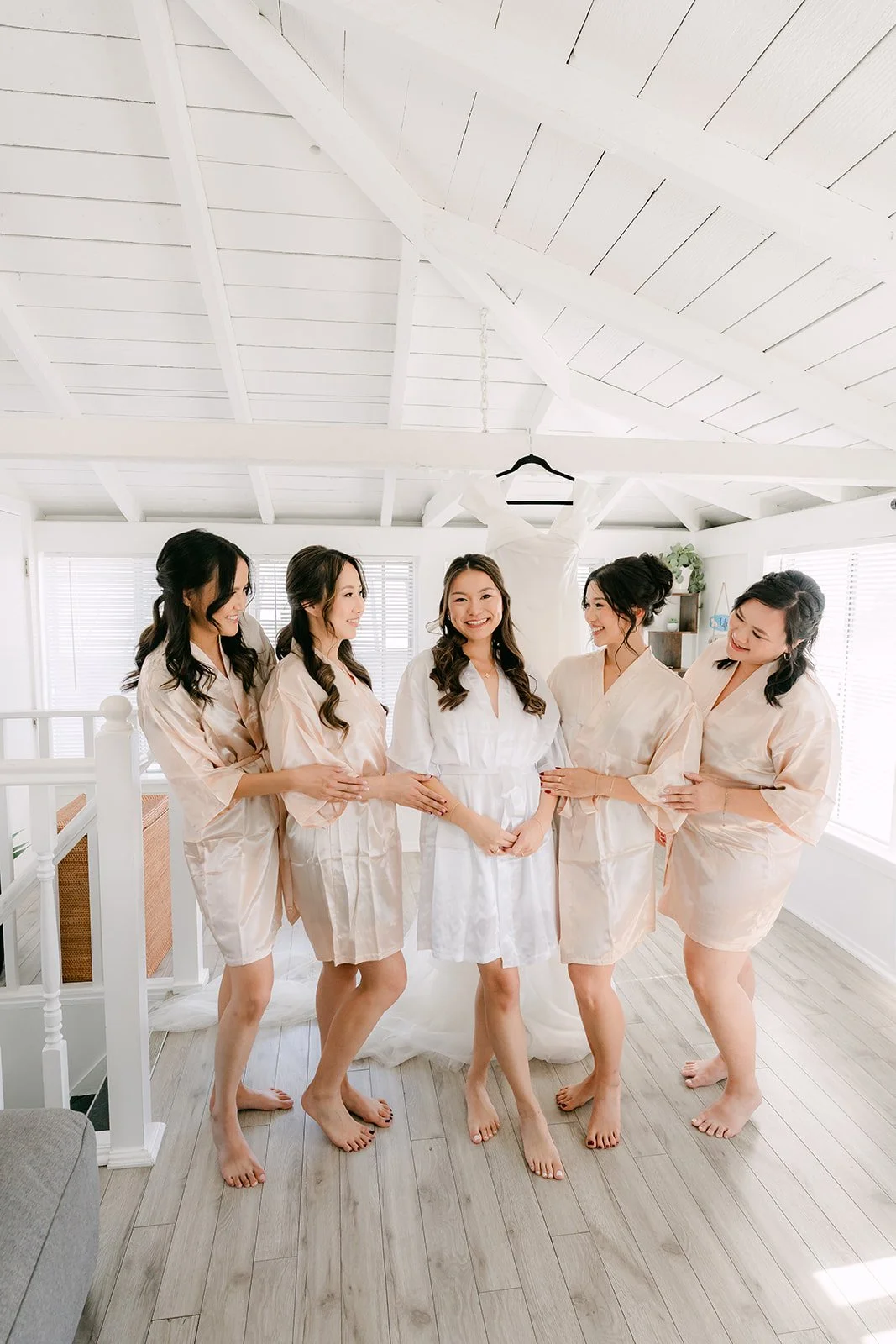 Bridesmaids in matching robes in the white room in Newport Beach