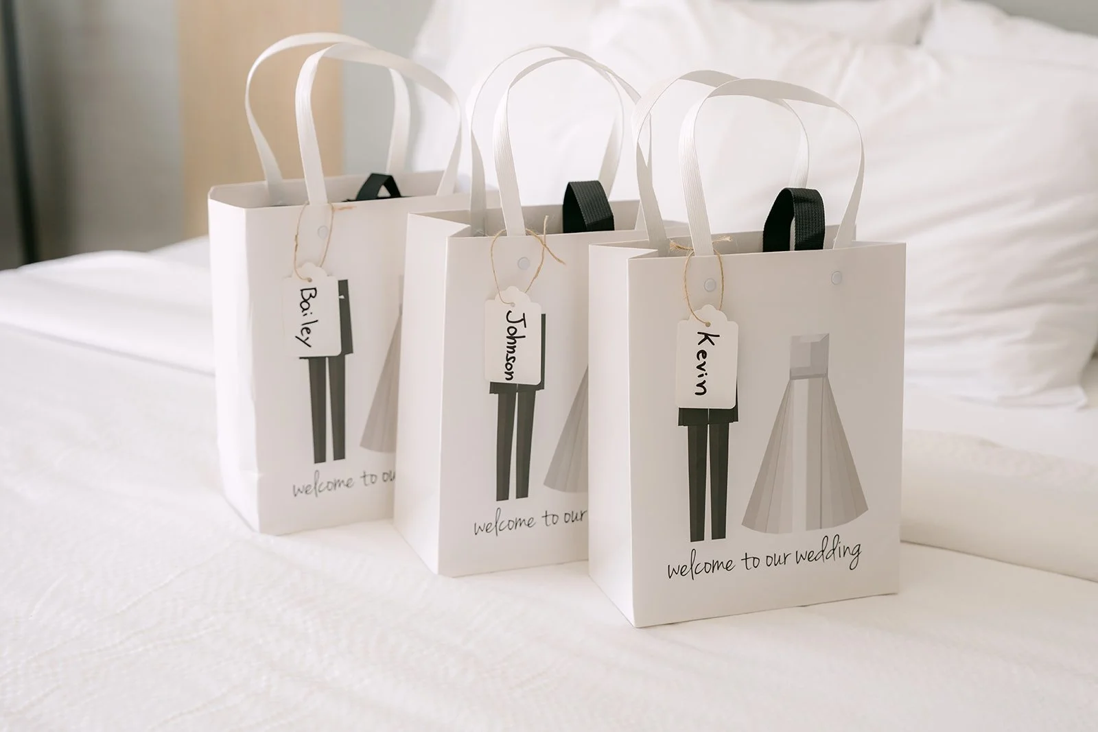 Gift bags for San's groomsmen lined up on the bed.