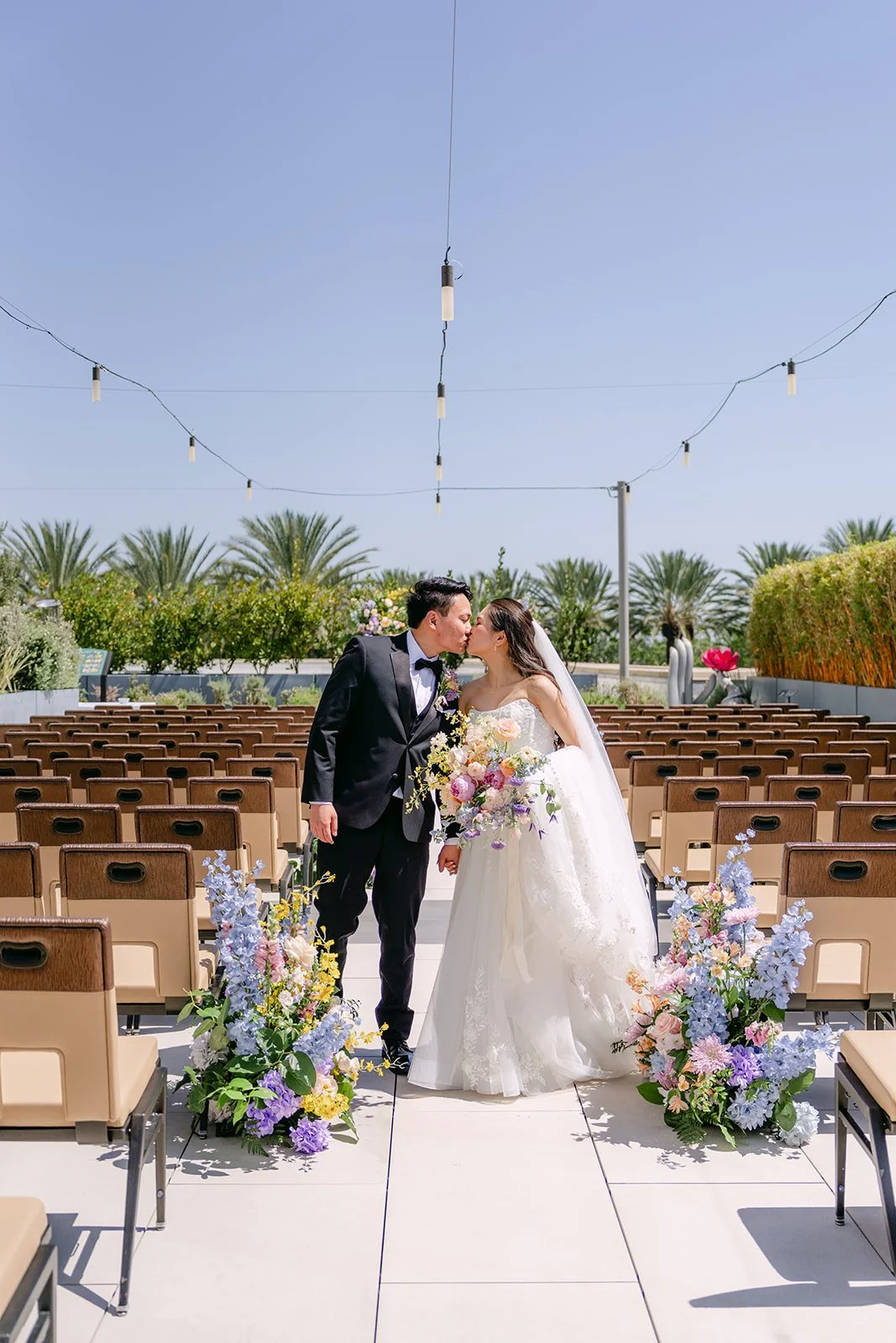 Hoan kissing Linh's cheek in the empty ceremony aisle