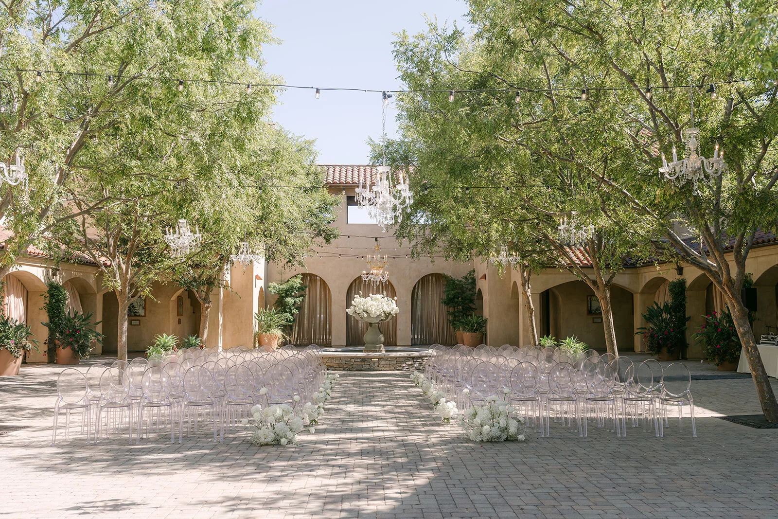 Wide view of the Serra Plaza courtyard ceremony under the trees