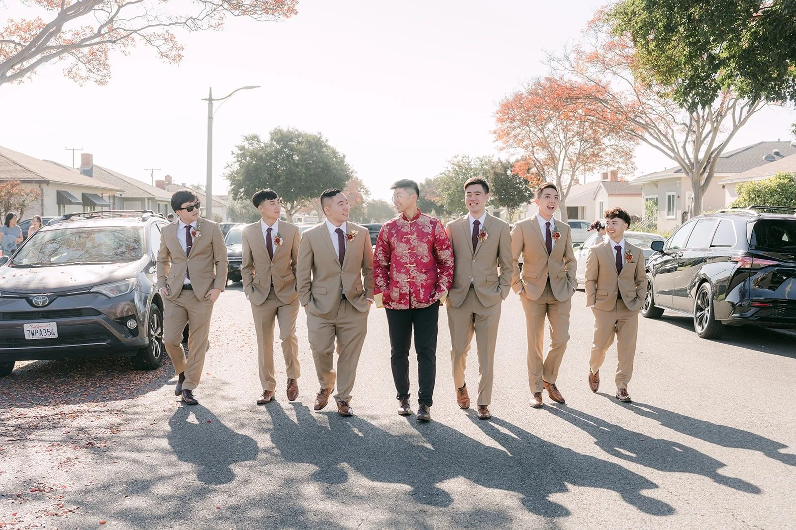 Robert and his groomsmen in tan suits walk up the street in Alhambra on the wedding morning