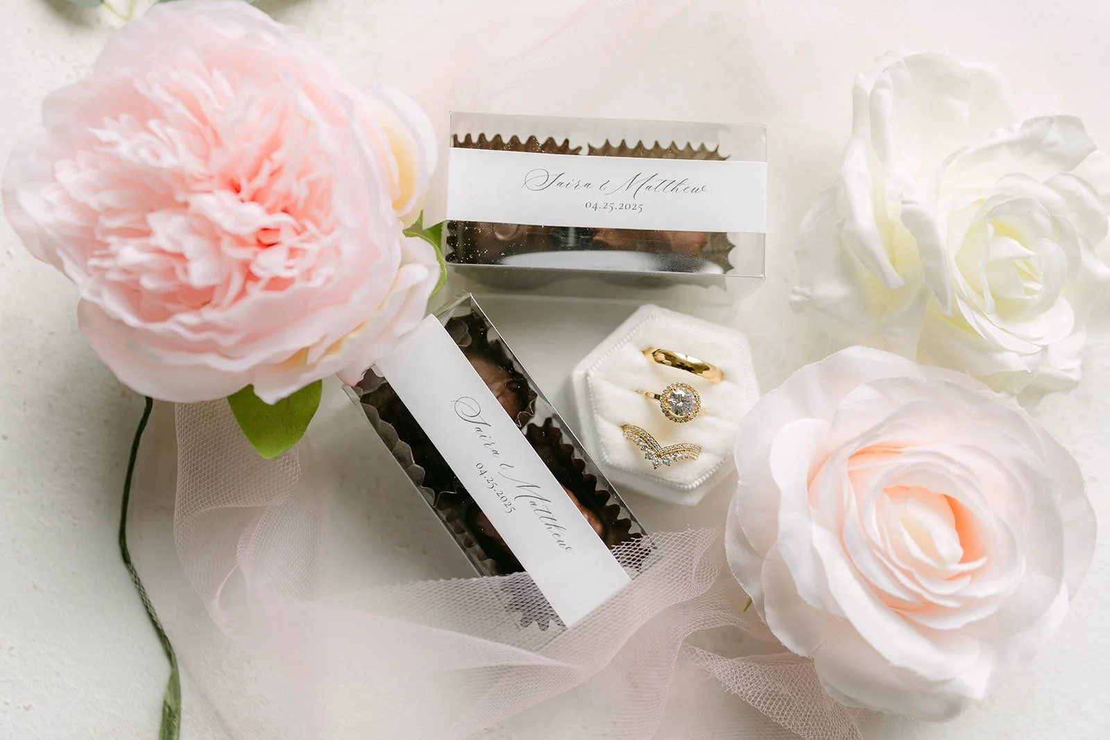 Saira and Matthew's wedding details styled with blush and white roses, a ring box and soft tulle
