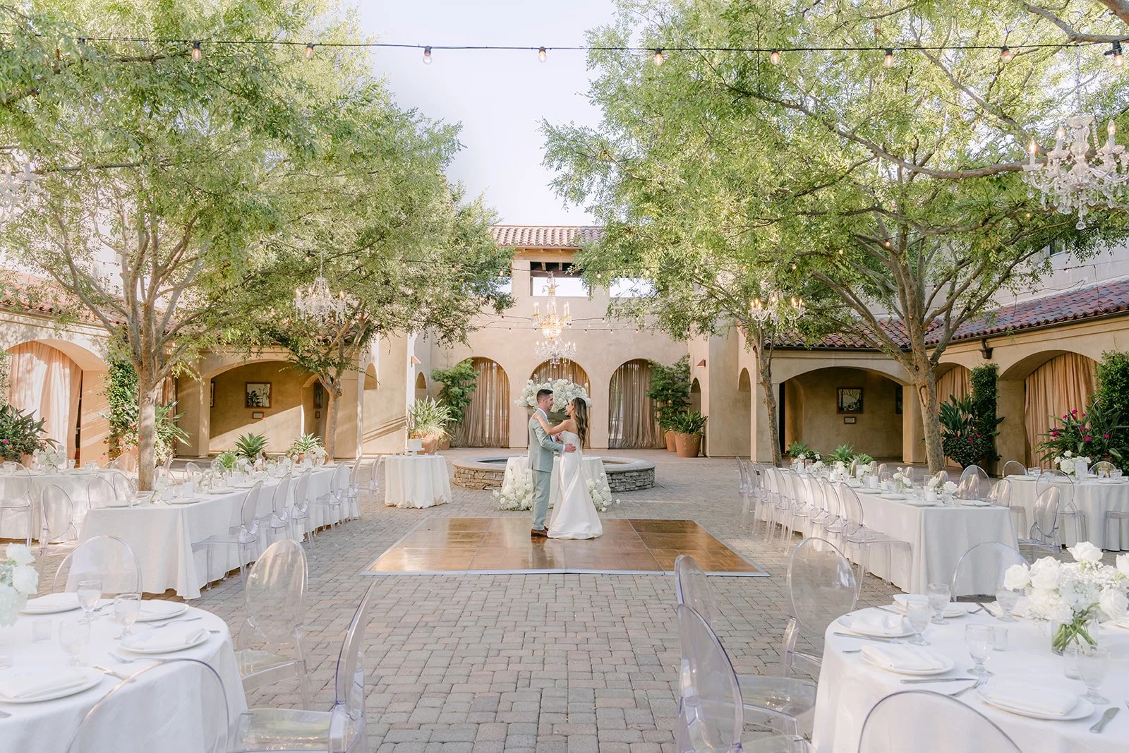 Wide view of the reception courtyard with the couple at the far end, photographed by One and Only Production