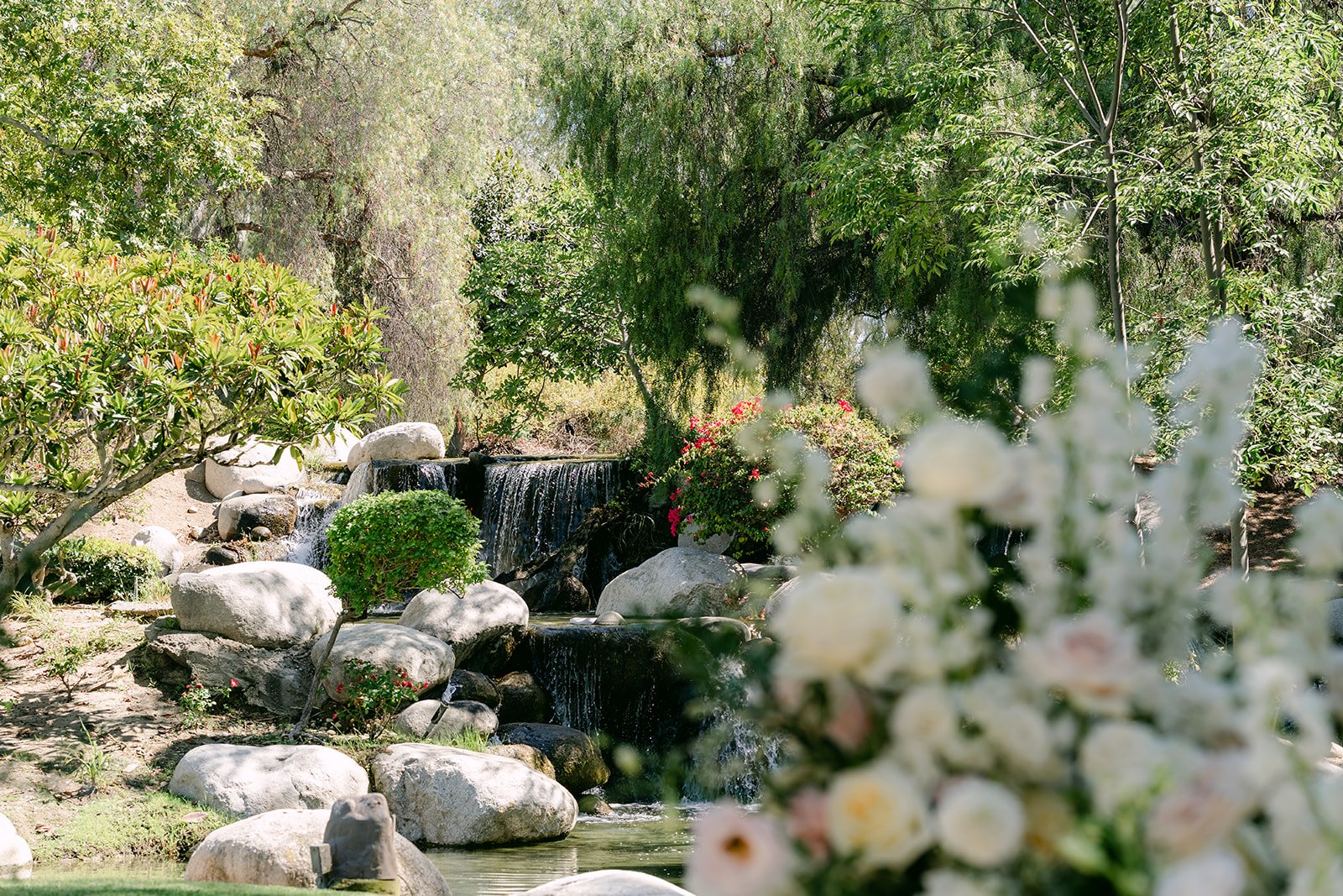 The rock waterfall behind cream ceremony florals at Coyote Hills.