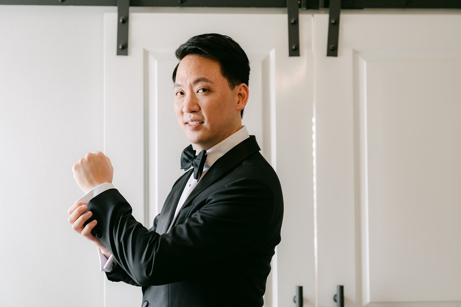 William pulling on his tuxedo jacket