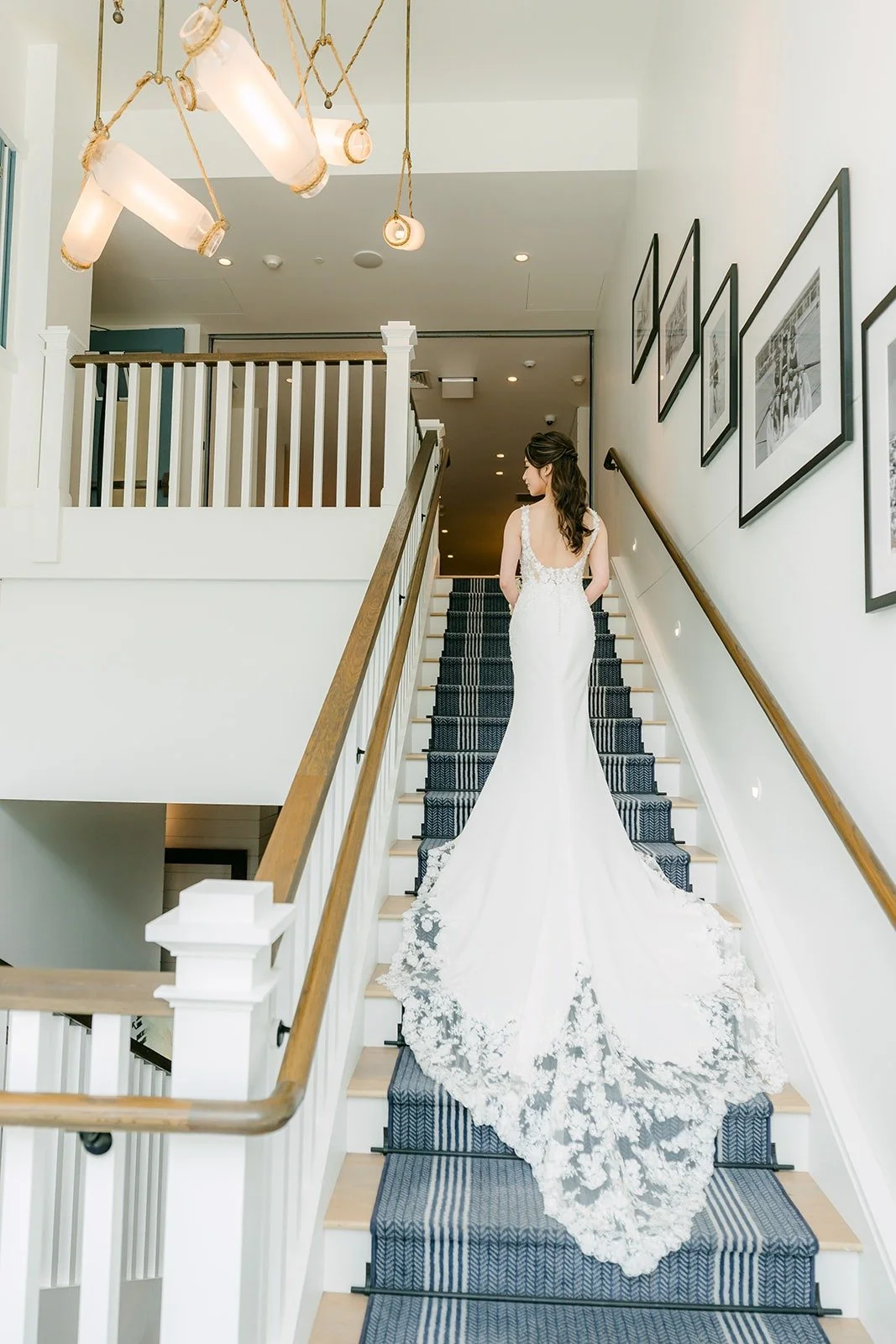 Angela walking down the blue patterned staircase with her lace train trailing behind