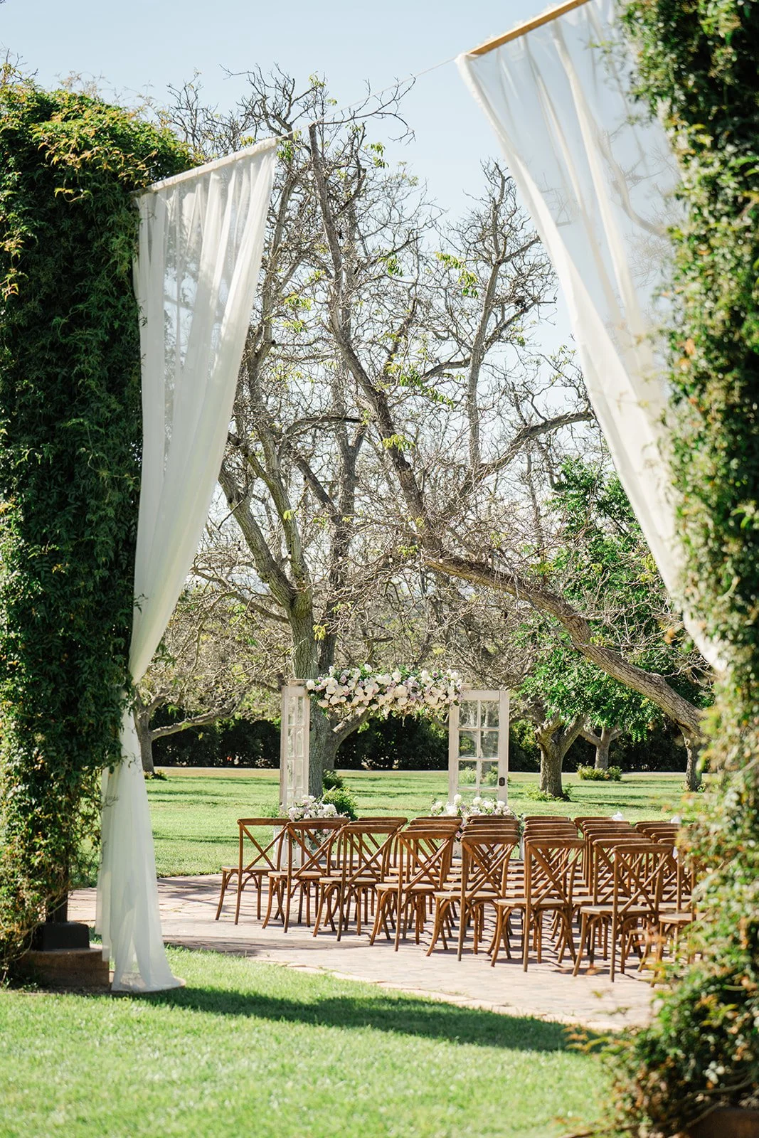 Draped ceremony entrance framing the walnut orchard