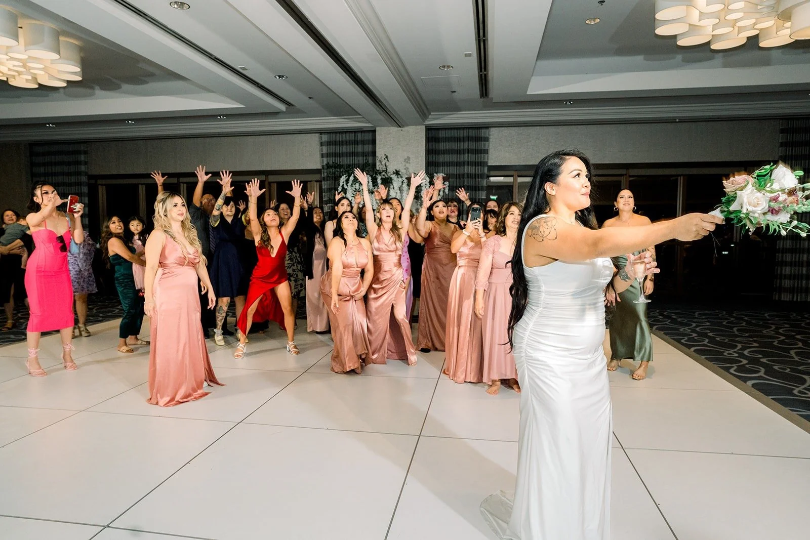Guests reach for the bouquet on the Beacon Ballroom dance floor