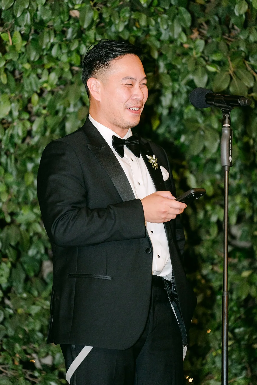 Best man giving a toast under the string lights at Eden Gardens.