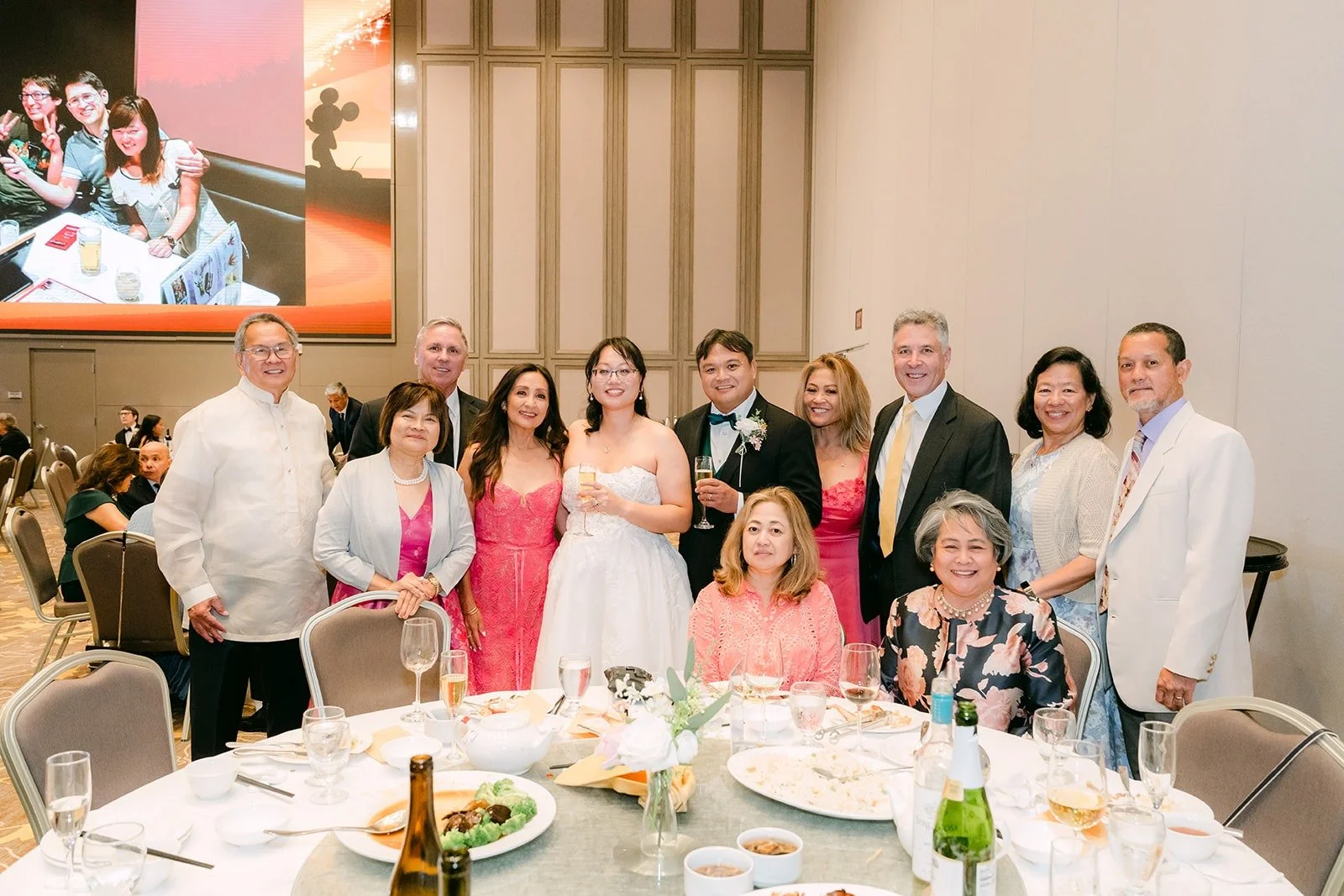 Stella and James posing with guests at their table during table greetings