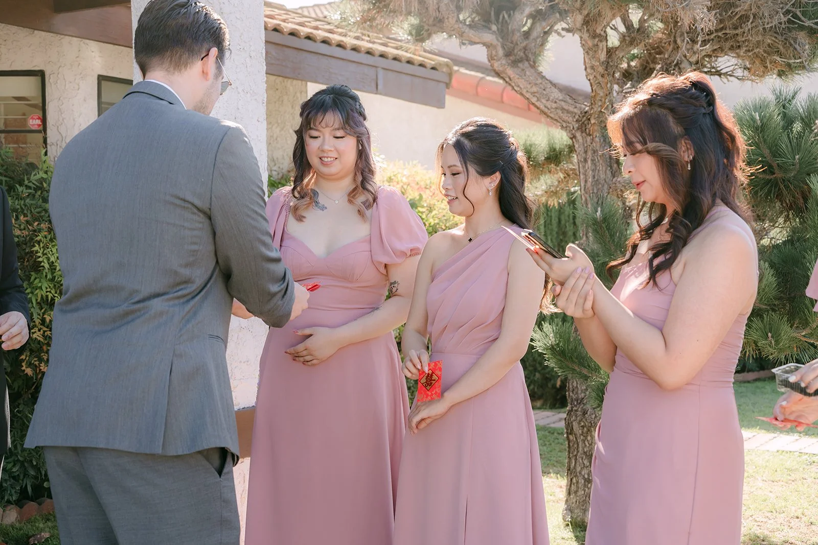 Bridesmaids holding the door against the groom, photographed by One and Only Production.