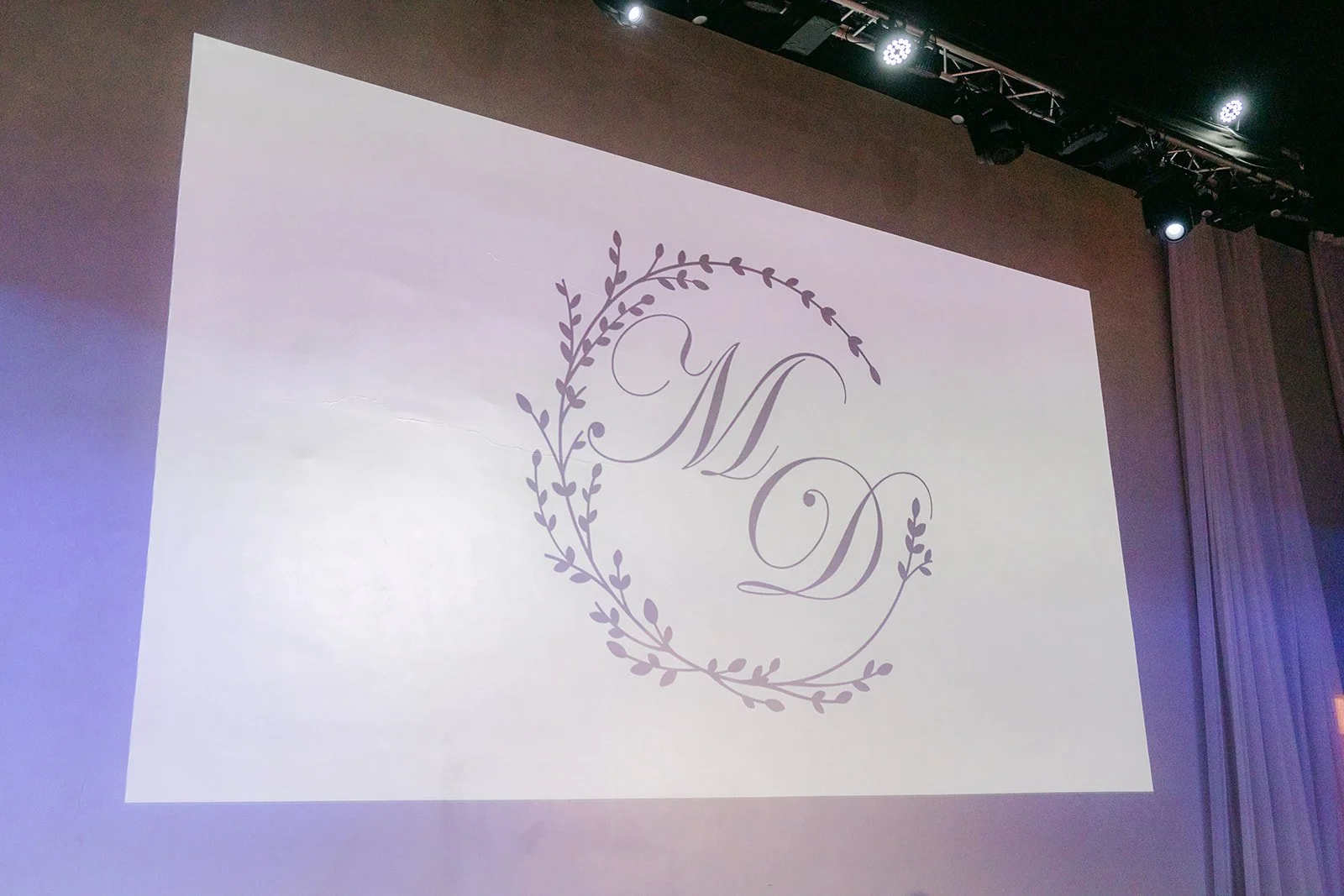 Mariana and Danny's monogram projected on the stage screen