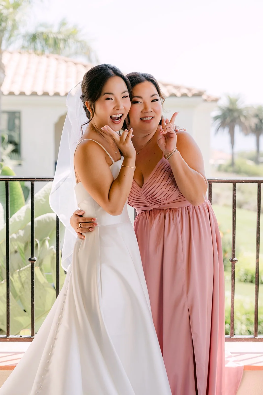 Saya sharing a first look with a bridesmaid on the balcony