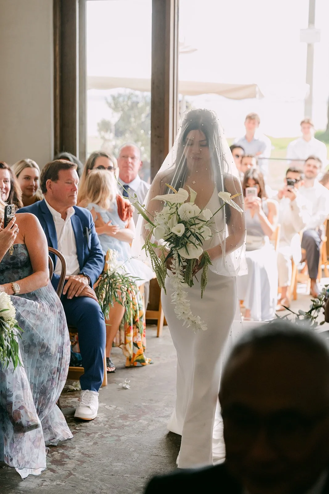 Justine walking down the aisle with her bouquet