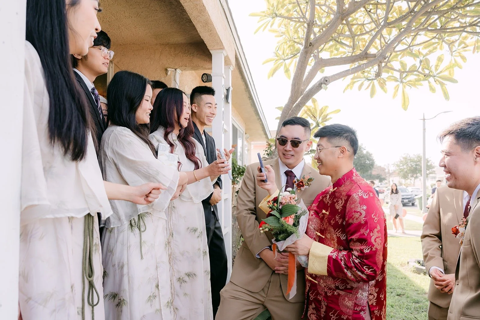 Bridesmaids in white challenge Robert at the front door, photographed by One and Only Production