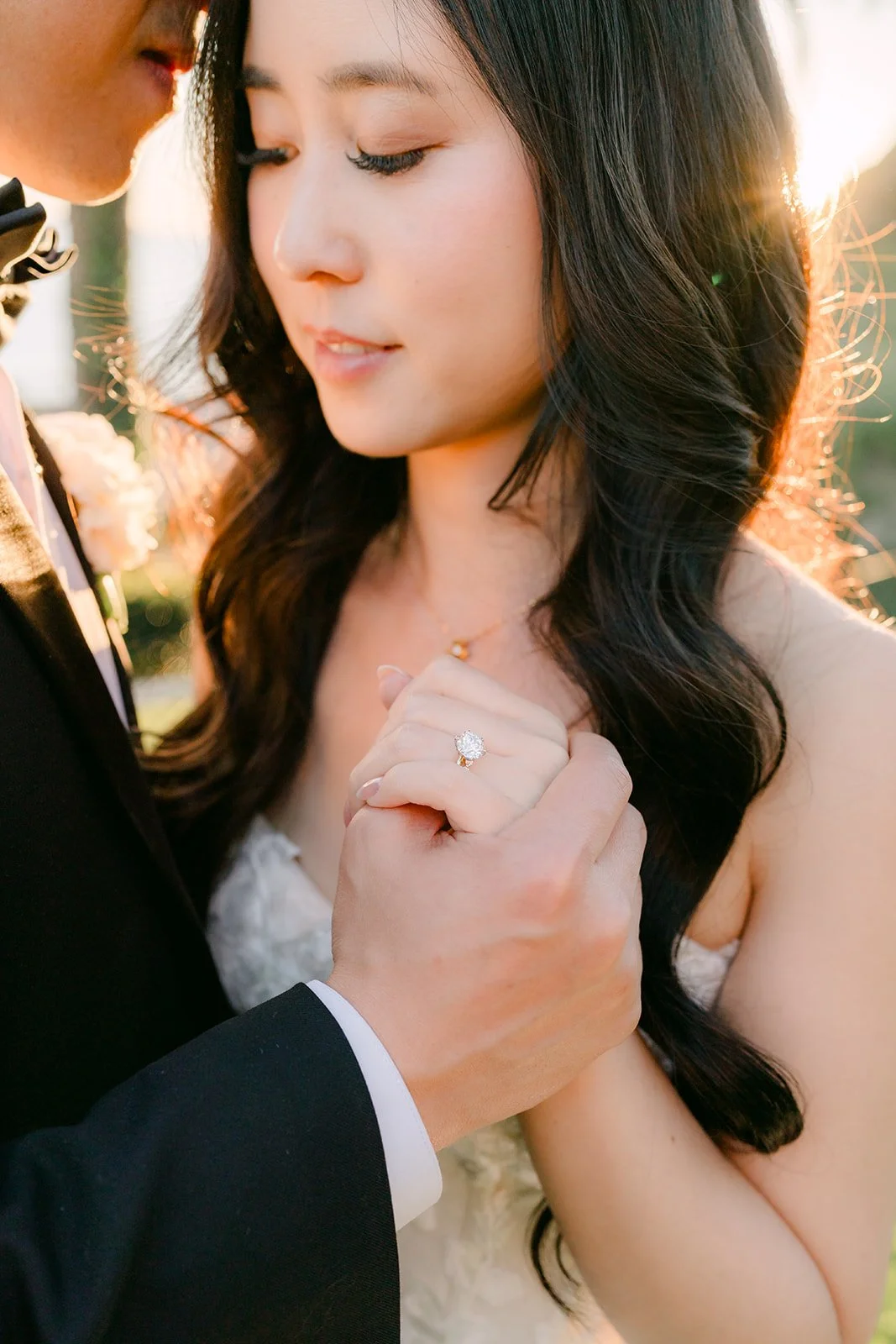 Bride holding the groom's hand close with her ring in focus