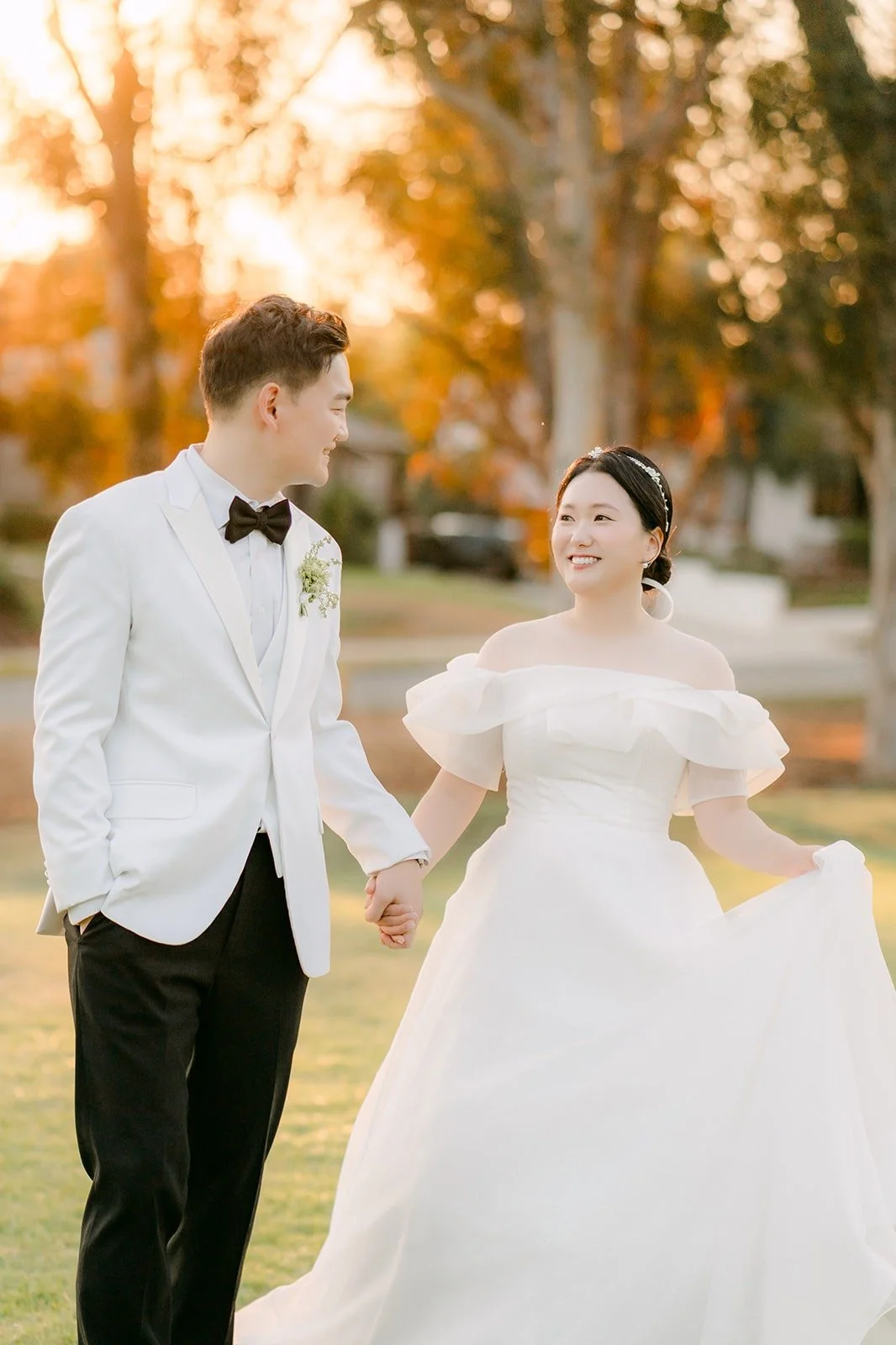 Sam in a white dinner jacket walking with Amy at sunset