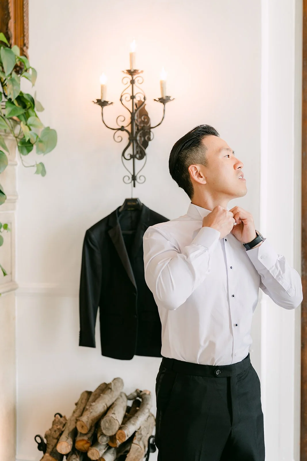 Groom buttoning the cuffs of his white shirt