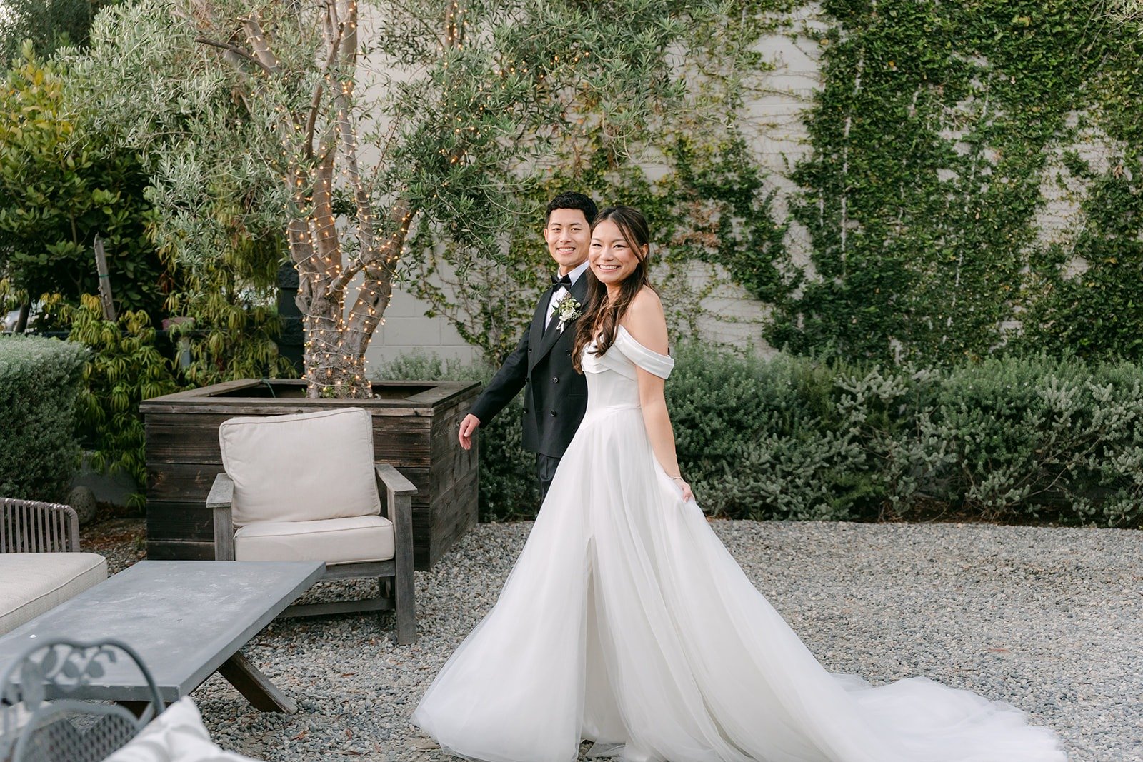 Jadee and Richard among the olive trees and lounge seating at The Harper