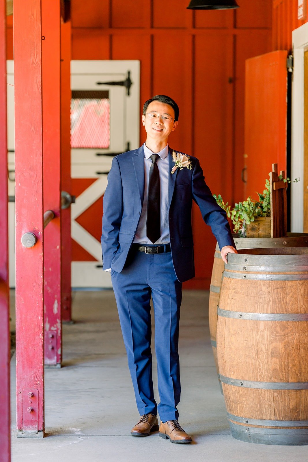 Alex beside a wine barrel at the red barn