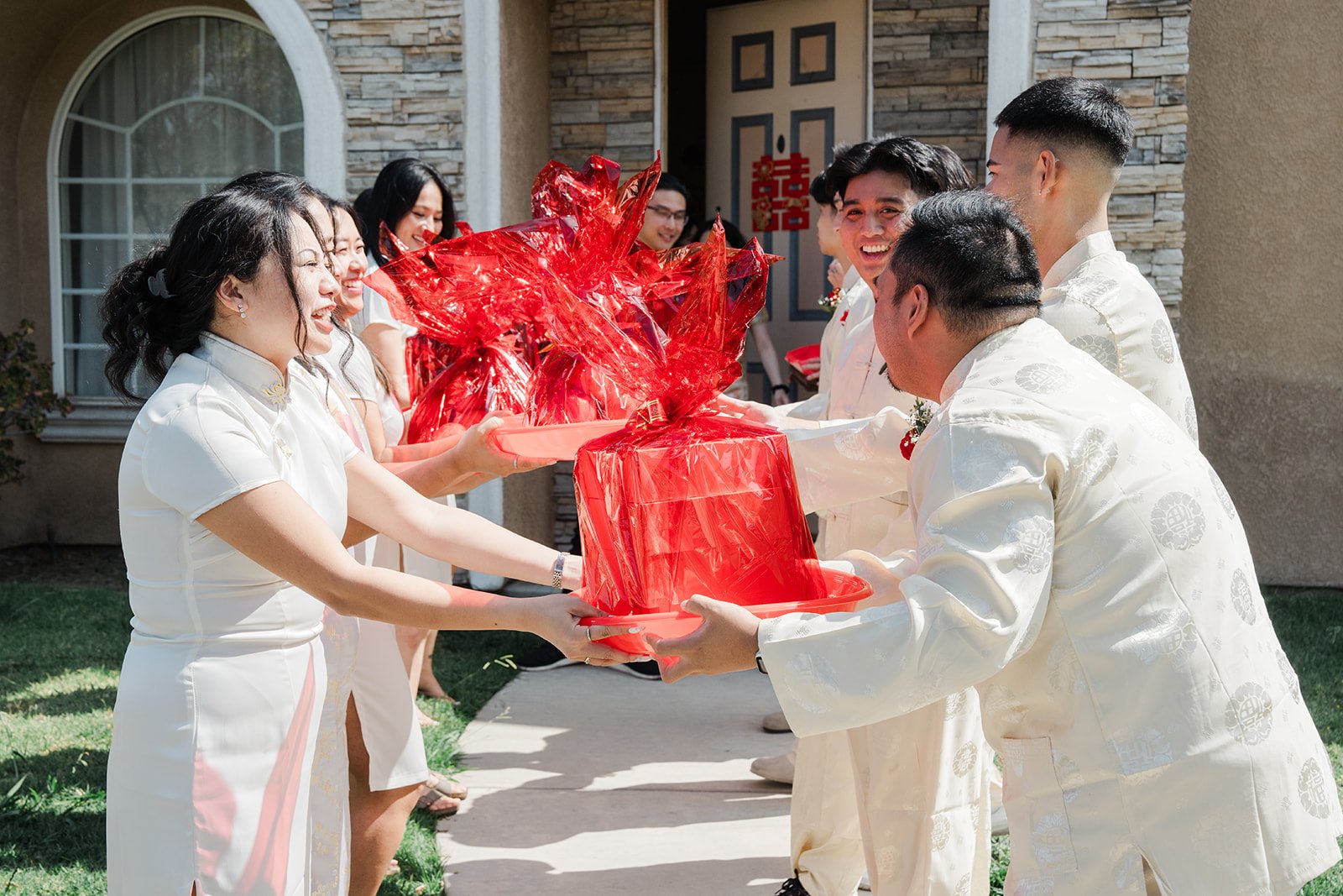 Bridesmaids and groomsmen exchanging trays at the front door.