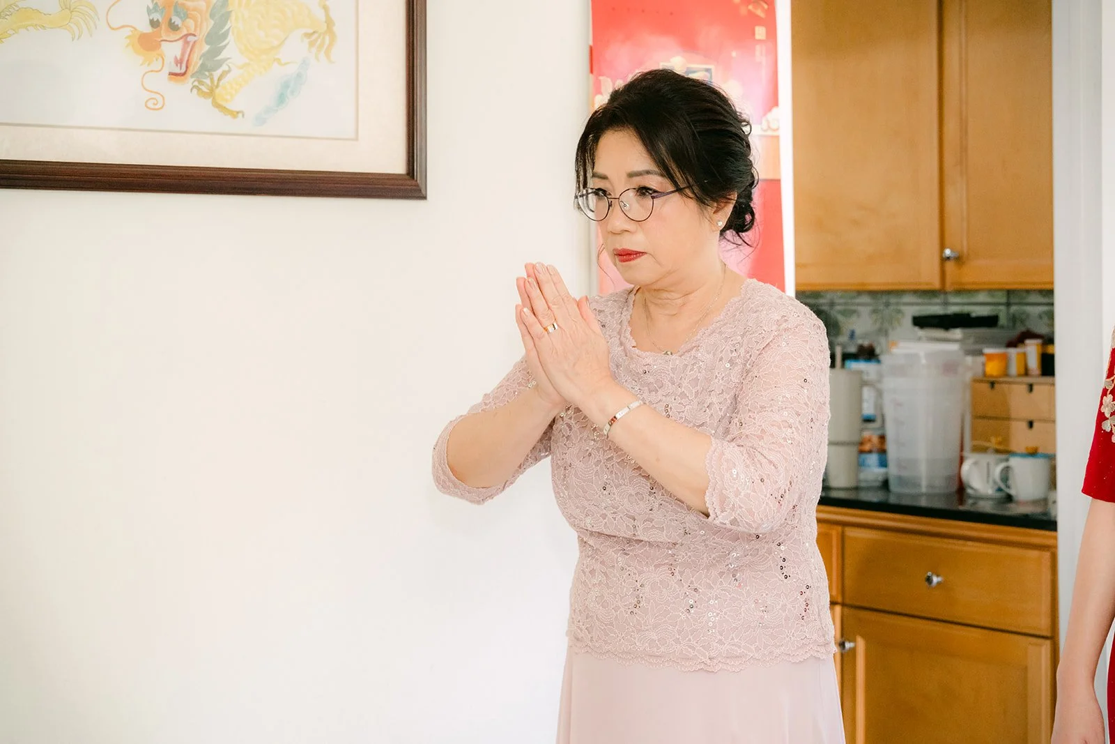 Pauline's mother smiling with her hands together.