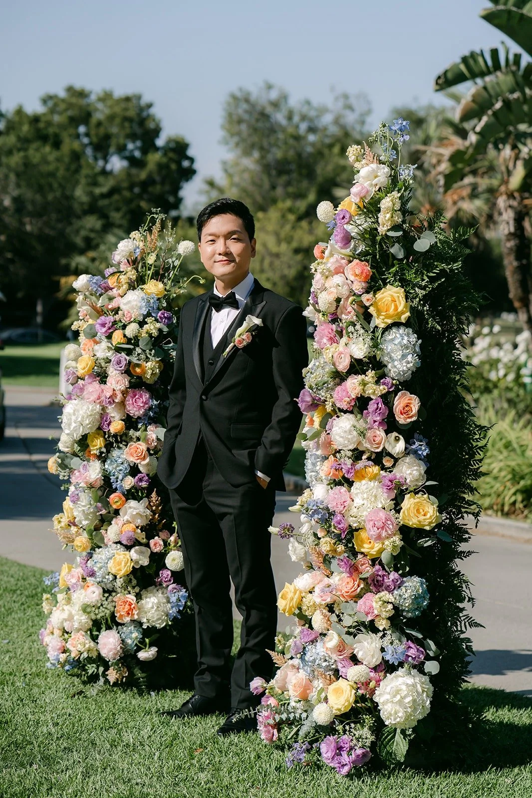 Eunsang standing between two pastel floral columns at the ceremony site