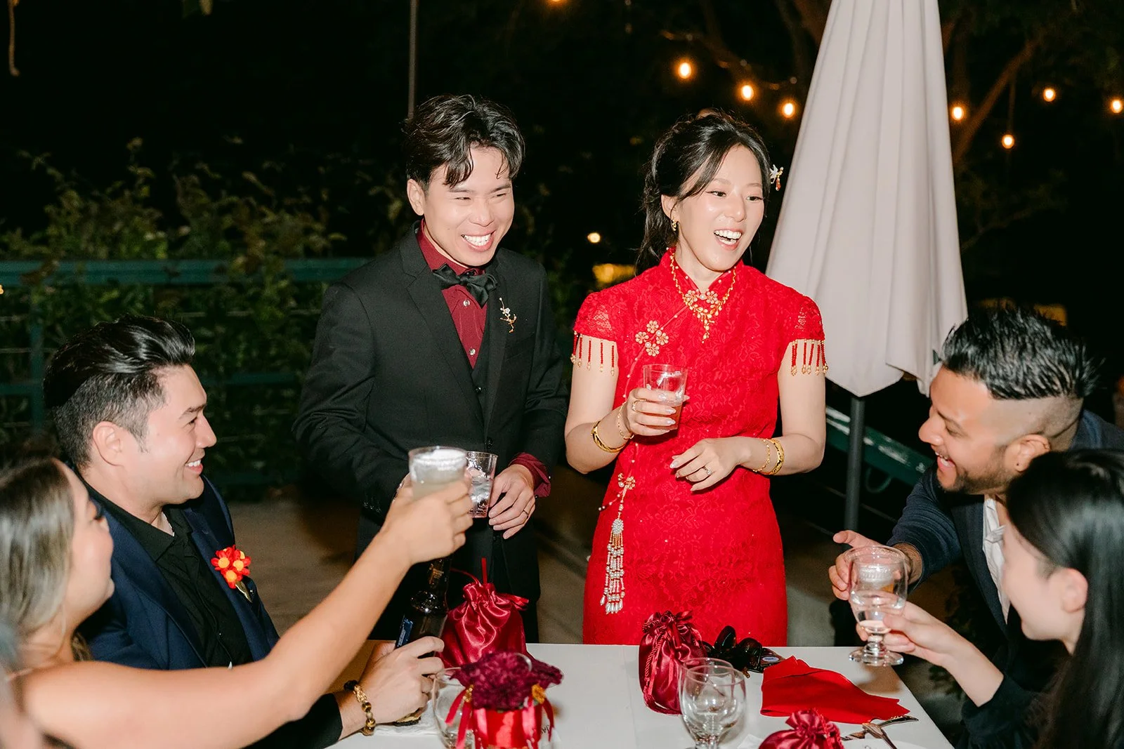 Elaine and Wen toasting a table of friends.