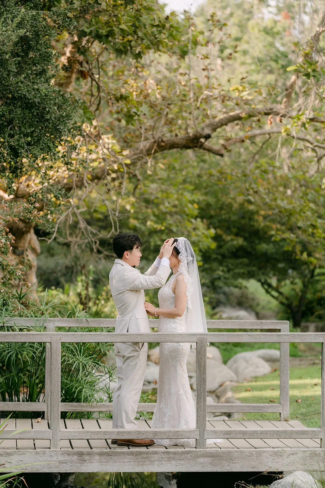 Elaine and Wen on the wooden bridge surrounded by greenery.