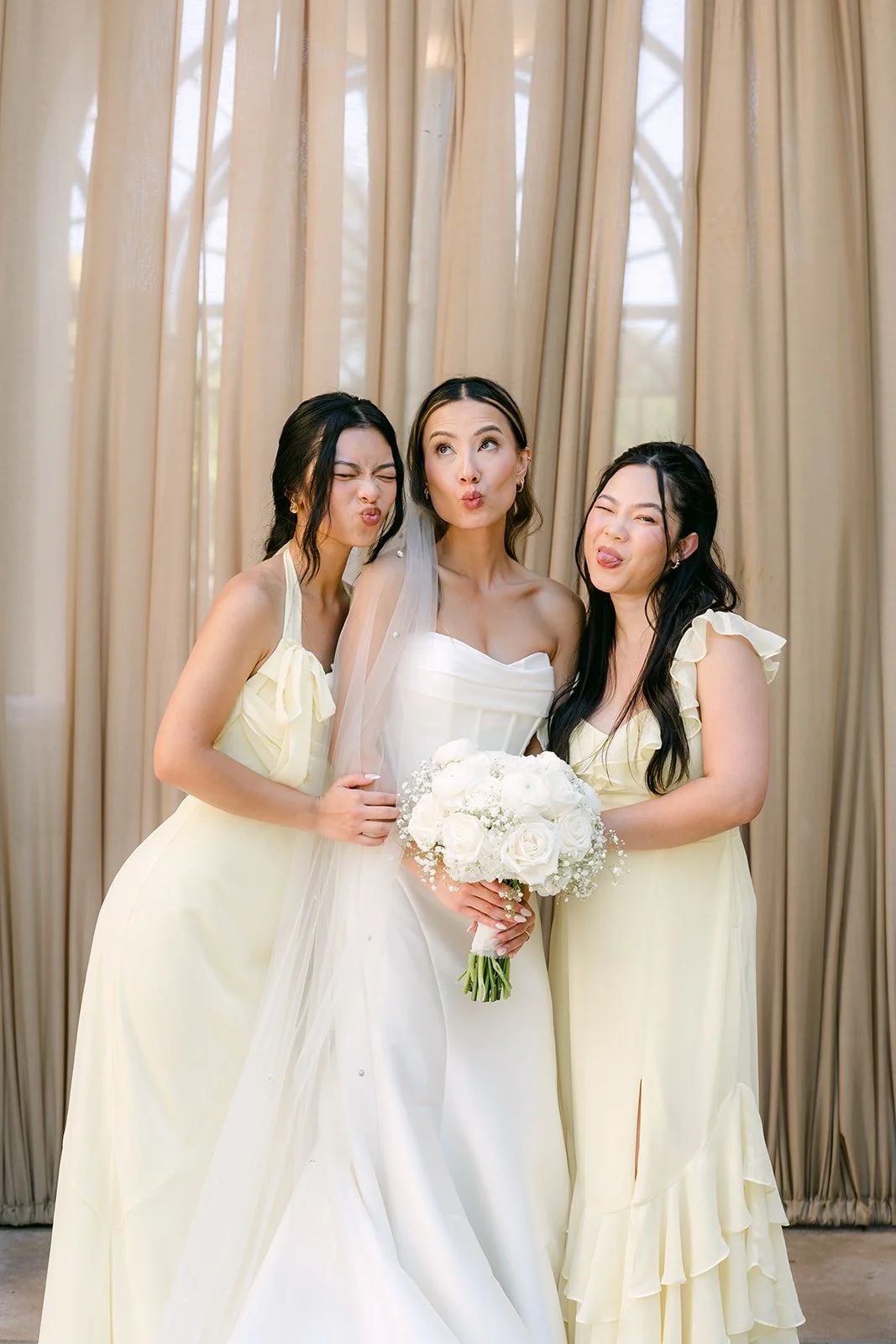 Bride with her two sisters in butter yellow bridesmaid dresses