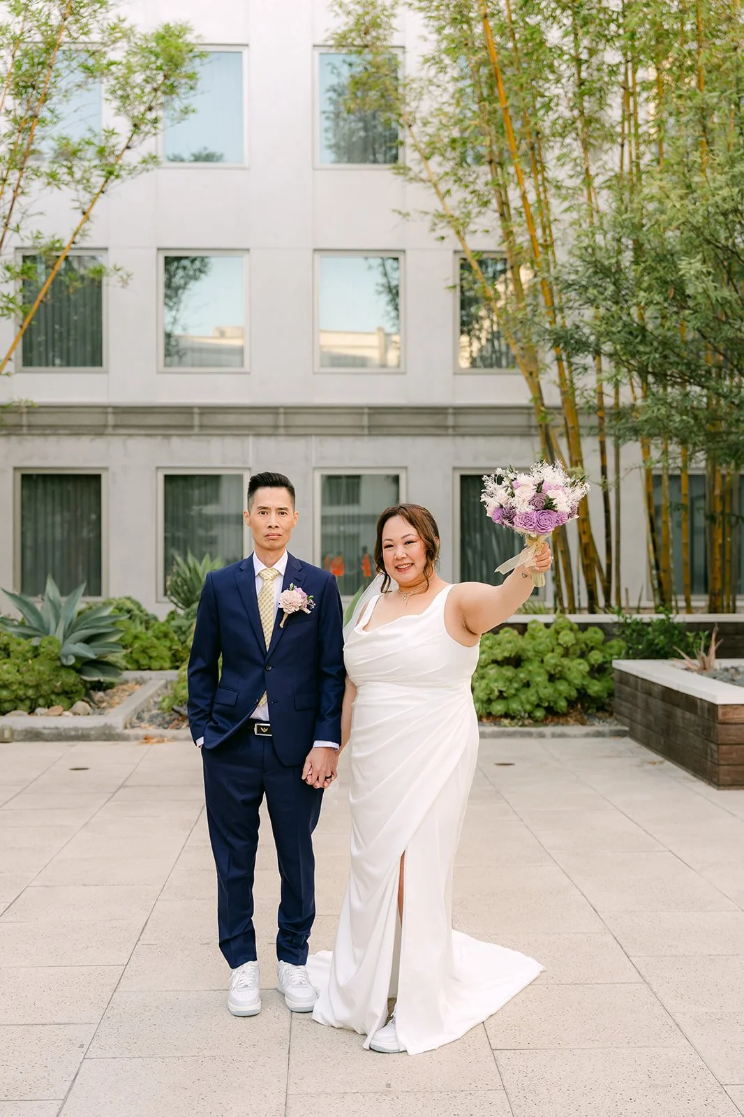 Mai raising her bouquet beside Bobby.