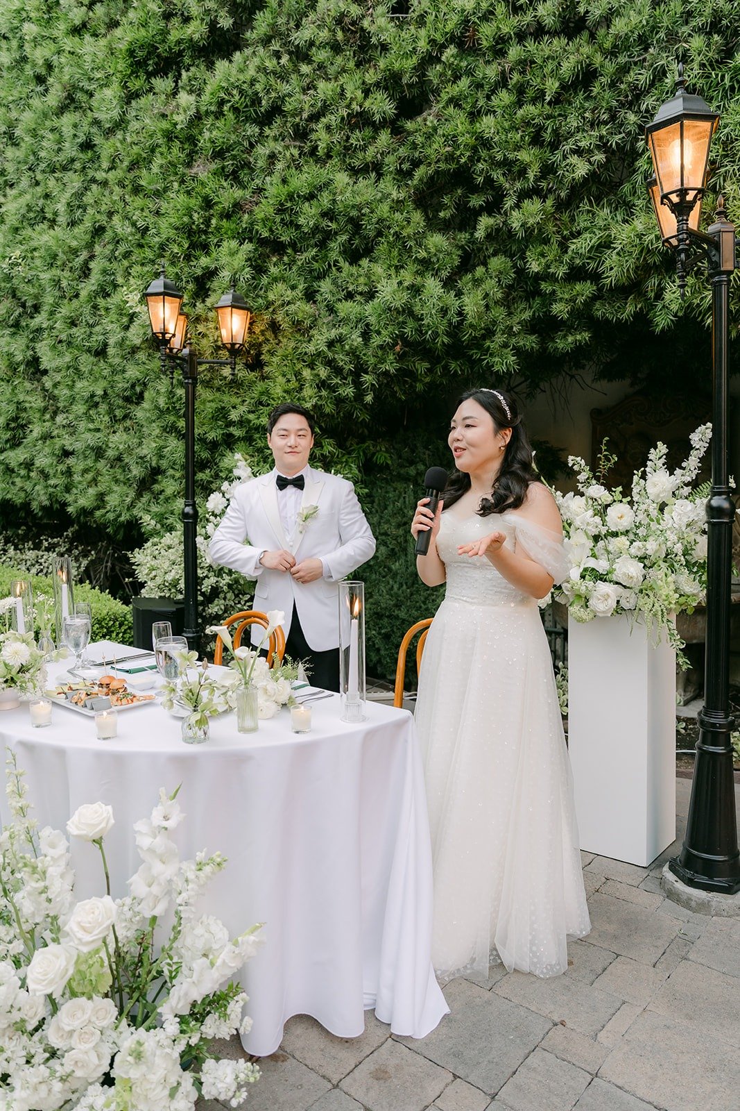Chorok and Min Soo standing at their sweetheart table to welcome their guests