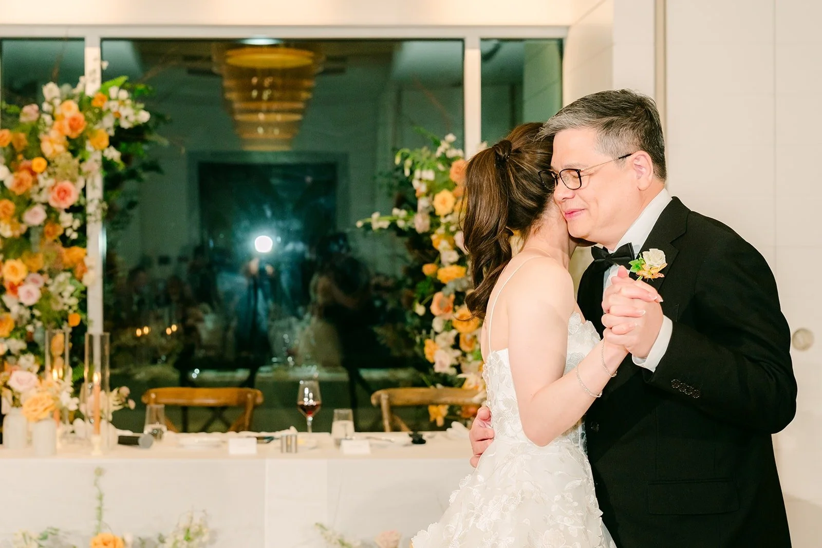 Angela sharing a parent dance beside the sweetheart table