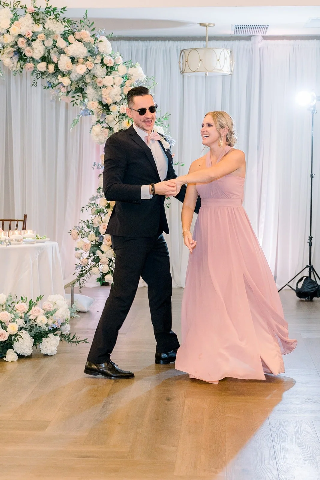 A bridesmaid and groomsman dancing into the reception