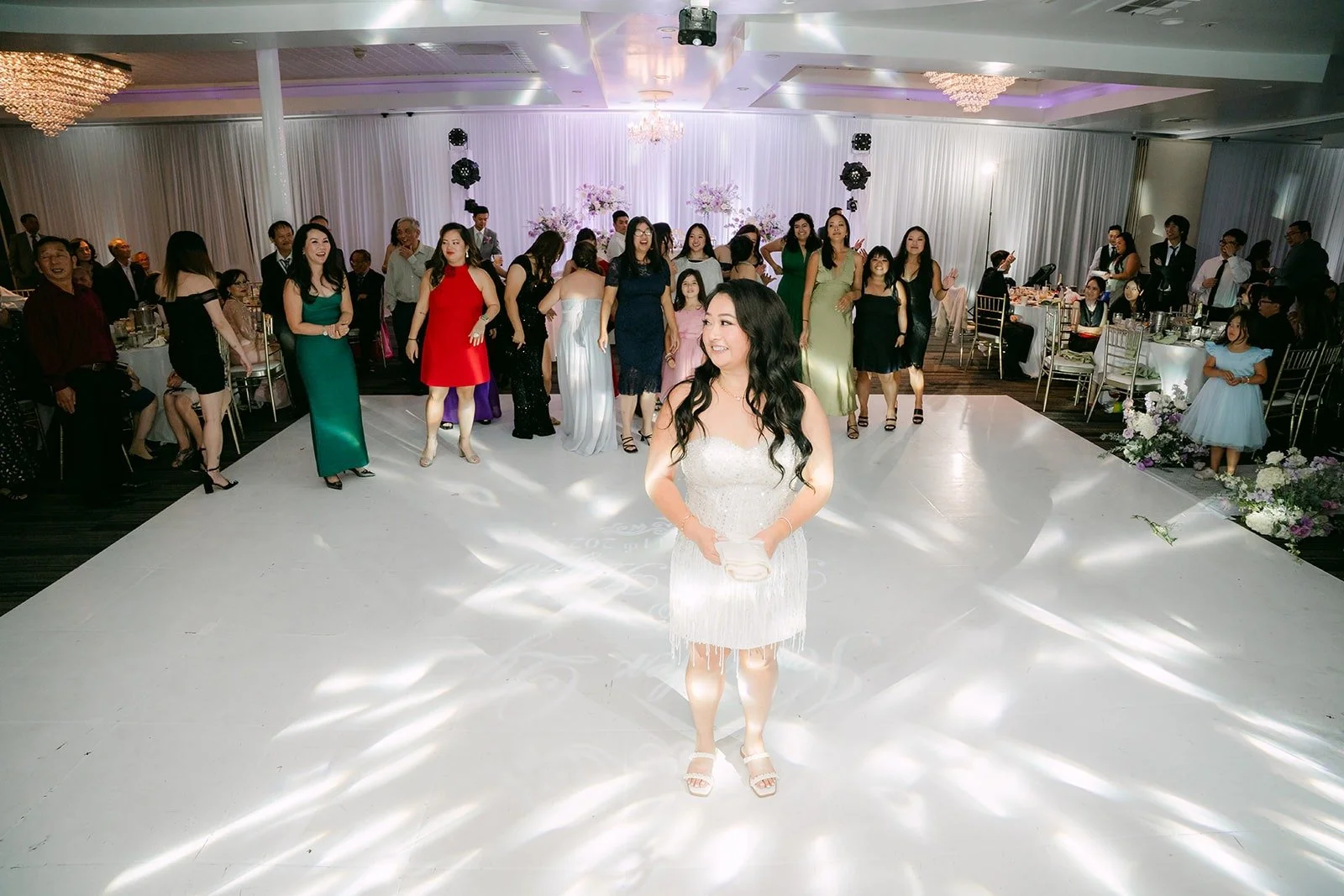 Jennifer in her short white dress on the dance floor before the t shirt toss