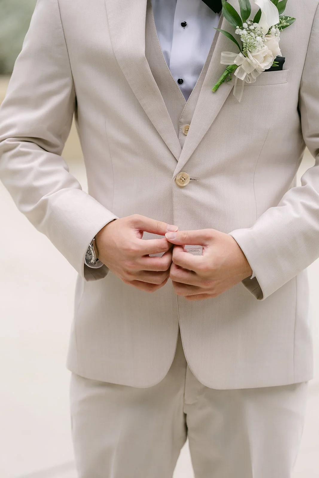 Wen buttoning his cream jacket.