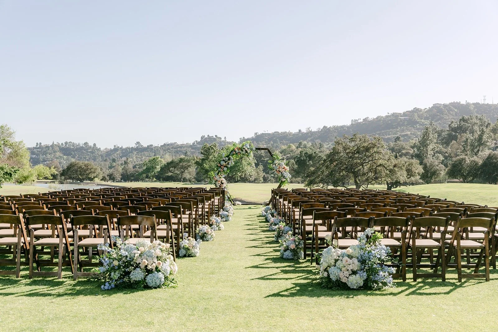 Ceremony setup with wooden chairs on the 15th hole at Brookside Golf Club