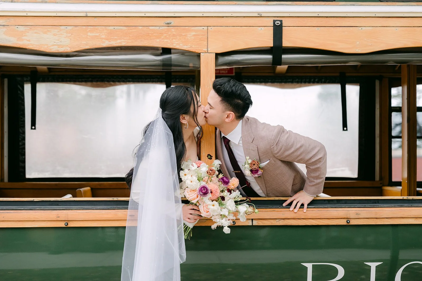 Denise and Michael kissing as they lean out of the green Richland trolley.