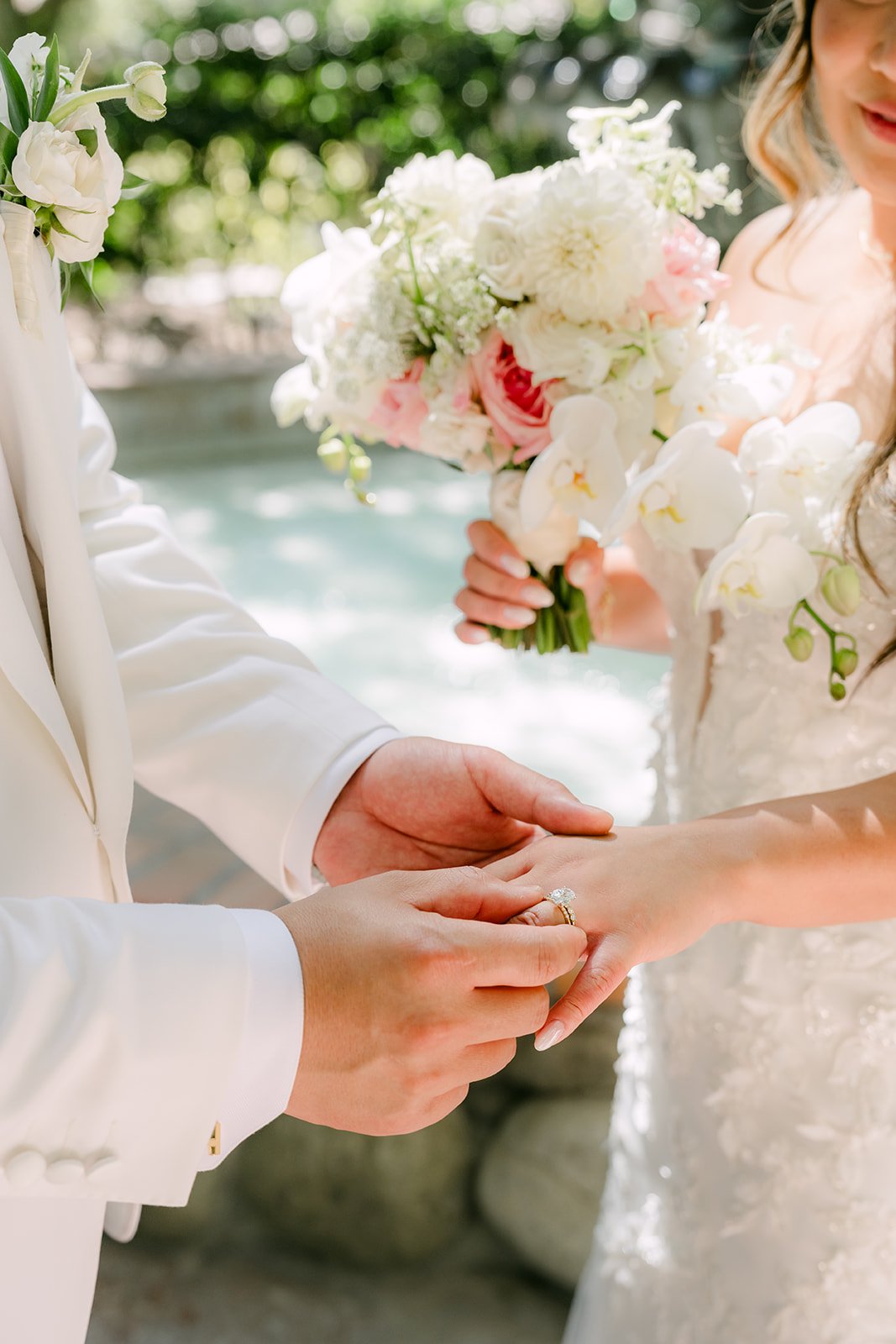 Caryl holding Nicole's hand as she holds her white and blush bouquet.