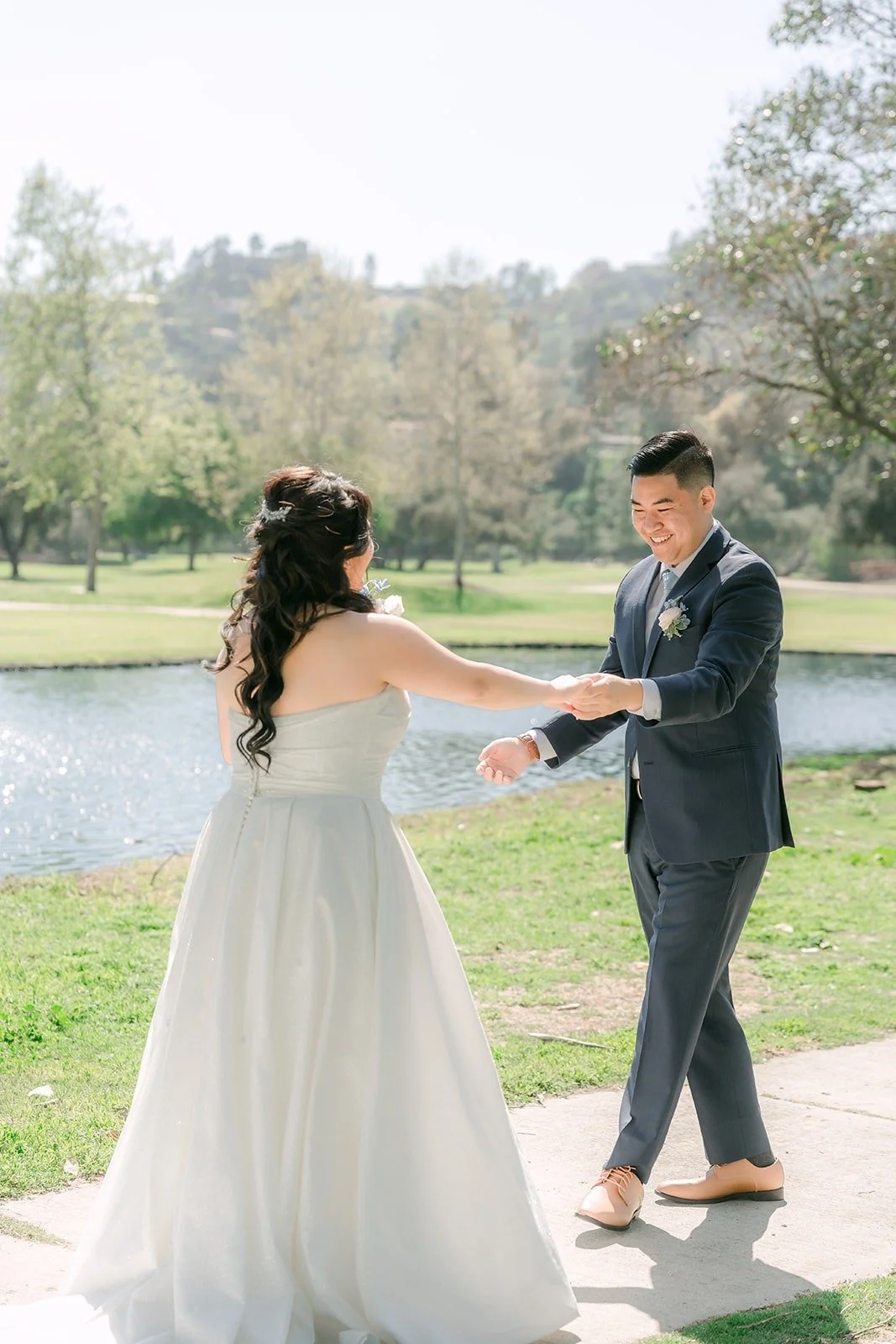 Florence reaching for Jordan's hands on the path by the pond