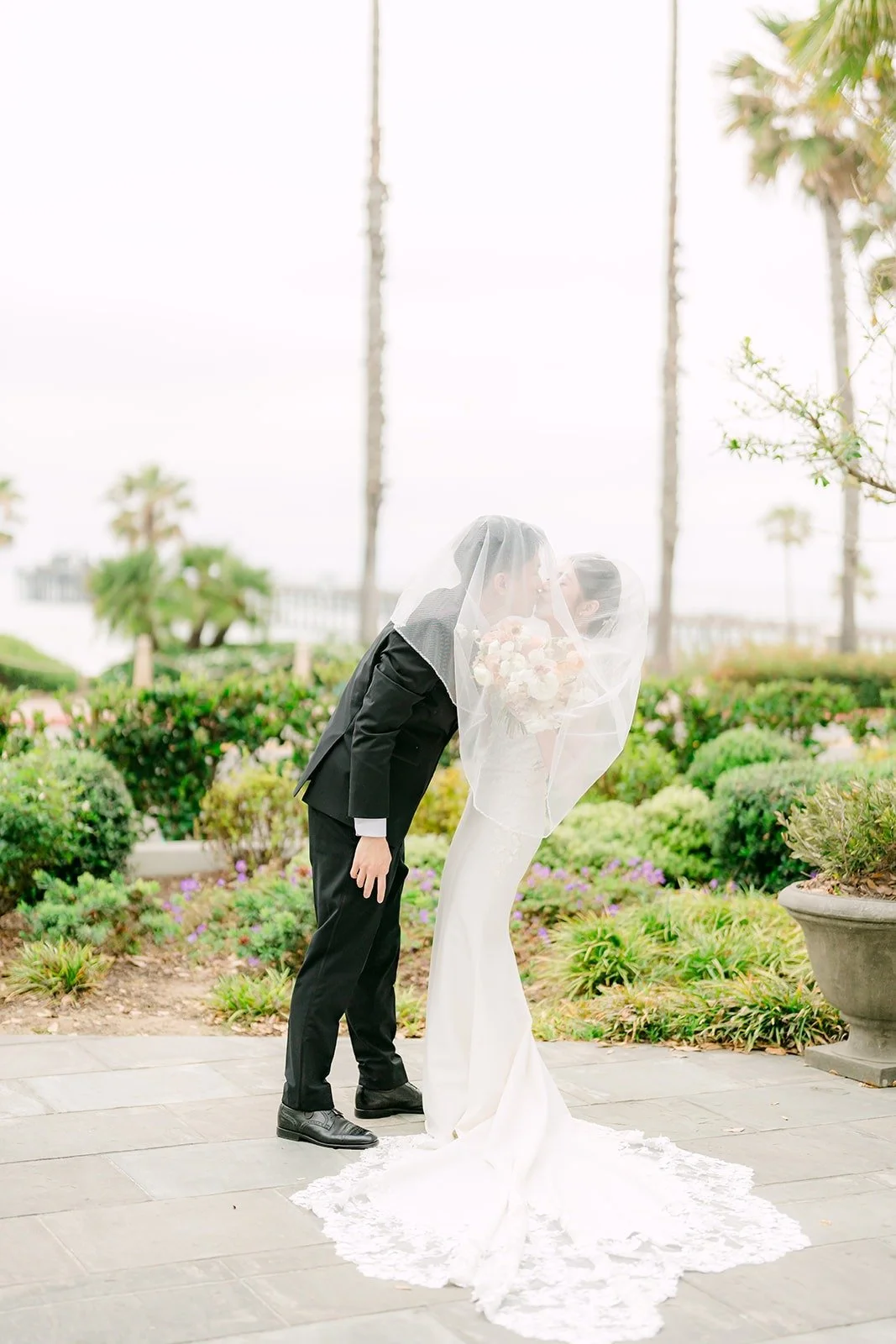 Eli lifting Angela's veil in the garden at Seabird Resort