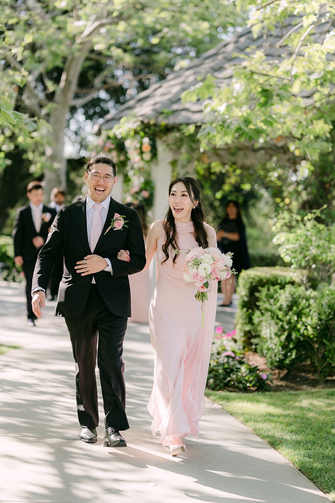 Judy and Joshua walking back up the aisle as newlyweds, photographed by One and Only Production