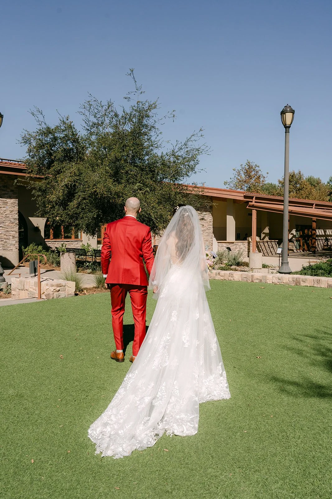 Christie and Christian walking together across the lawn after the ceremony, photographed by One and Only Production.